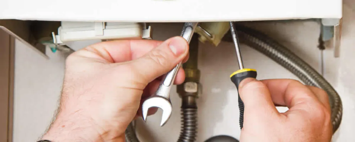 Boiler repair technician tightening pipe fittings and connections in Fort Collins, CO