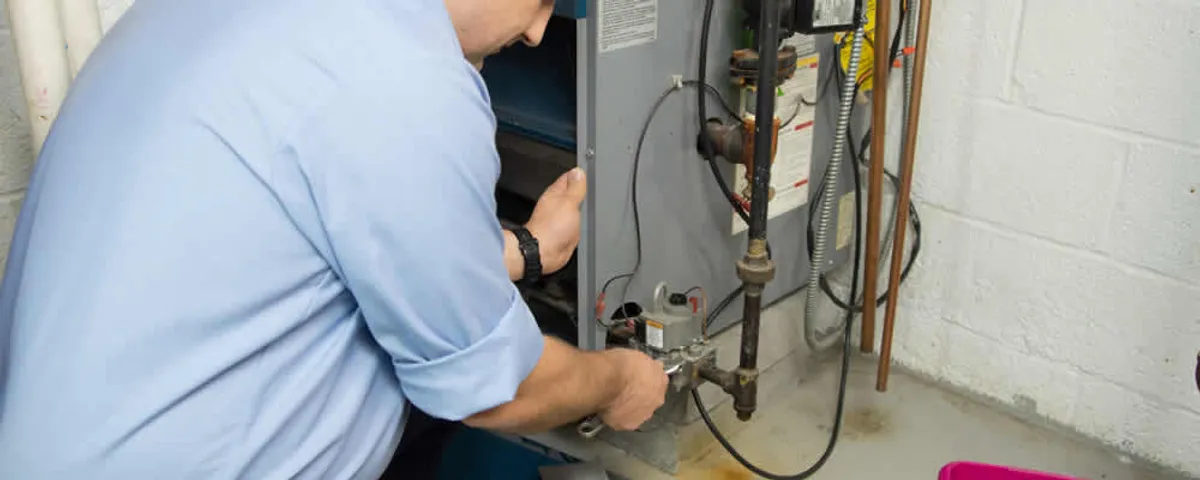 Furnace repair technician inspecting and servicing a home heating system in Fort Collins, CO
