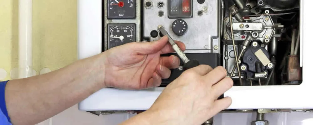 Heating repair technician adjusting boiler controls and components in Fort Collins, CO