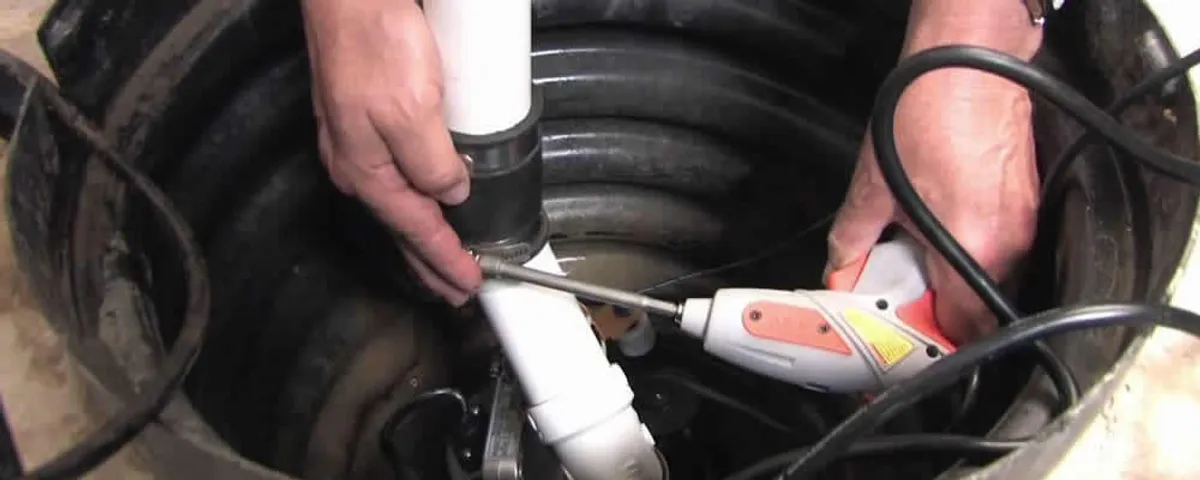 Sump pump installation technician connecting PVC discharge piping in Fort Collins, CO