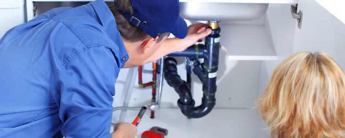 Plumber repairing under-sink drain pipes and fittings in Fort Collins, CO